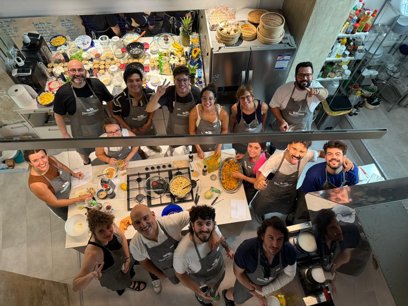 Grupo de participantes con delantales posando durante un taller de cocina en grupo en OCOA, Málaga